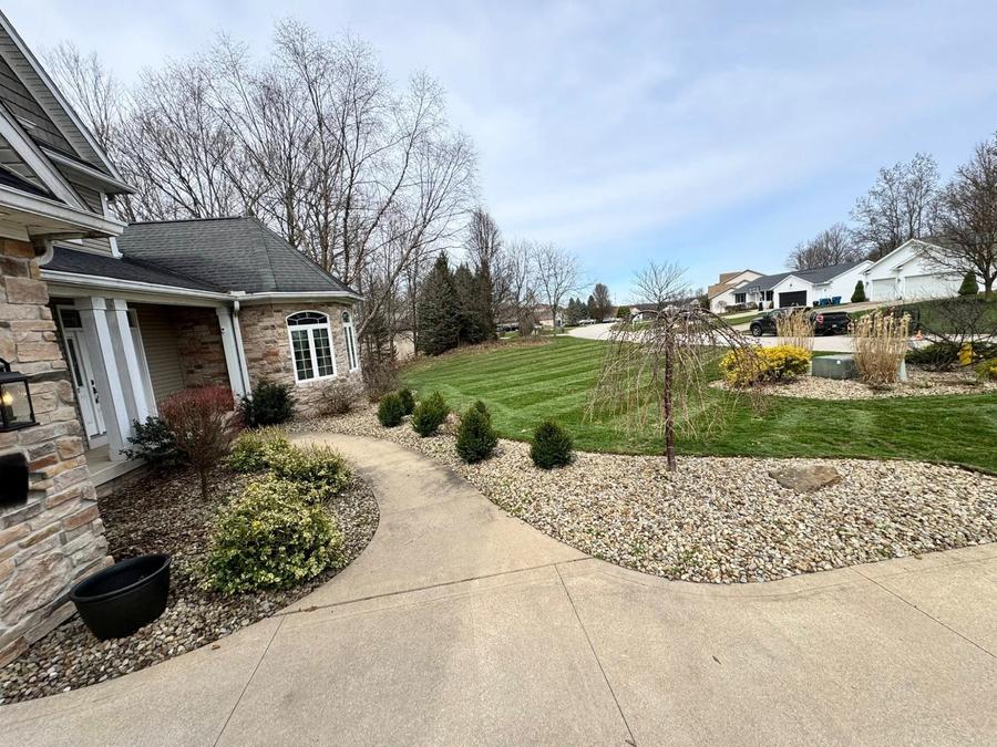 Professional landscaping with stone walkway and manicured shrubs