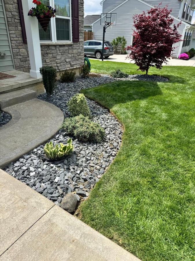 Slate rock bed landscaping with clean lawn edge