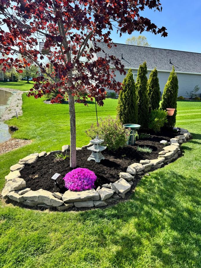 Stone border garden bed with flowering plants